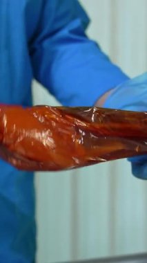 Uzman sosis yapar. Fabrika işçisi özel bir makine kullanarak sosis yapıyor.