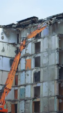 Eski Konut Binası 'nın Yıkılması. İnşaat alanındaki Buldozer Mekanik Kolu kullanarak Eski Beton Binasını Yıkmak.