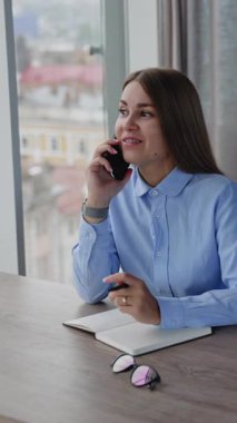 Yetişkin, kendine güvenen kadın internet yöneticisi. Akıllı telefonlu bir kadın yönetici. Dikey video