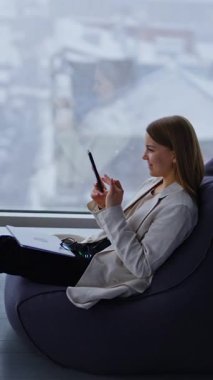 Akıllı telefon kullanan genç bir kadın. İşletme müdürü telefonla konuşuyor. Dikey video