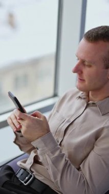 Modern ofiste çalışan profesyonel bir işletme yöneticisi. Telefondan kendine güveni tam bir iş adamı. Dikey video
