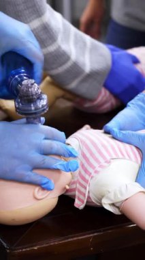 Kardiyopulmoner resüsitasyon öğretiyorum. Bebek eğitim bebeğine kardiyopulmoner resüsitasyon uyguluyorum. Dikey video