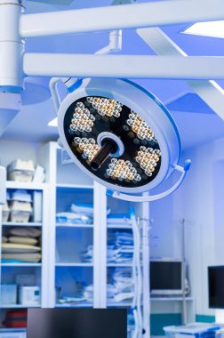 Nöroşirürji için yüksek teknolojili ışıklandırma. Parlak cerrahi ışıkları, nörocerrahların kritik bir prosedüre hazırlandıkları ameliyathaneyi aydınlatıyor..