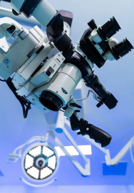 Modern neurosurgery tools. High-tech surgical microscope is set up in a neurosurgery operating room, showcasing the precision tools available.