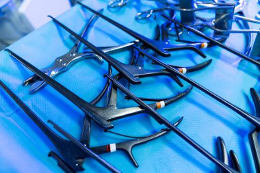 Key neurosurgery tools. Surgical instruments are arranged on a sterile blue surface in a neurosurgery operating room.