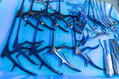 Surgical tools set up. Various surgical instruments are neatly organized on a blue surgical drape in a neurosurgery operating room.