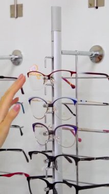 Optik dükkanındaki kadın. Vitrindeki bardakları çeken kadın ellerini kapat.