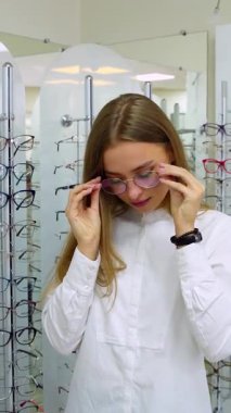 Optik mağazasındaki kadın. Optik mağazasında gözlük seçen mutlu kadın.