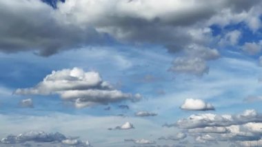 Gökyüzünde süzülen kümülüs bulutlarının büyüleyici görüntüsü. Rüzgârın savurduğu bulutlara alçak açılı bir bakış açısı. Zaman Uygulaması.