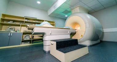 MRI donanımlı tıbbi görüntüleme odası. Tıbbi görüntüleme odasında MRI makinesi, hazırlık alanı ve hasta taramaları için gerekli ekipmanlar bulunur..