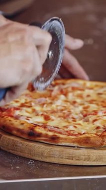 İtalyan pizza hazırlığı. Pizza kesen aşçının ellerini kapat.