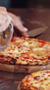 Şef pizza kesiyor. Şef taze pizza kesiyor.