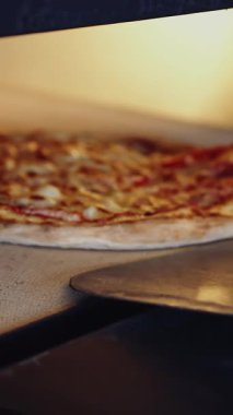 Geleneksel İtalyan pizzasını hazırlıyorum. Restoran şefi geleneksel restoranda fırından pizza alıyor.