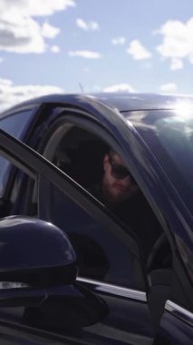 Arabadaki yakışıklı, vahşi adam. Sıradan bir genç adam lüks bir arabaya biniyor.