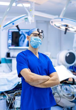 Cerrah karmaşık bir ameliyat için hazırlandı. Bir cerrah kendine güvenerek bir ameliyathanede duruyor ve bir hasta üzerinde önemli bir işlem yapmaya hazır..