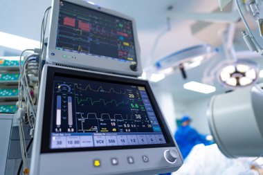 Ameliyat odası: gelişmiş monitörler. Cerrahi ekip modern bir ameliyathanede kritik bir işlem sırasında gelişmiş izleme ekipmanları kullanır..