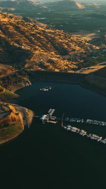 Kaliforniya 'da dağlarla çevrili yatlar ve tekneler için rıhtımı olan güzel bir göl. Kayaların arkasındaki yeşil vadiler çok güzel. Dikey video