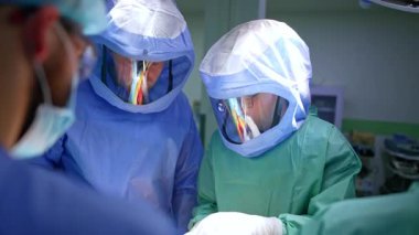 Koruyucu kasklı profesyonel erkek cerrahlar operasyonda çalışıyor. Ortopedi, ameliyatta travmayı iyileştirir..