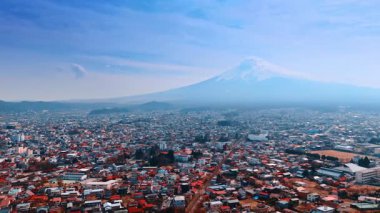 Puslu Fuji Dağı 'nın eteklerine dağılmış güneşli şehir manzarası, Honshu, Japonya. Stratovolcano yakınlarındaki kentsel bölgede hava perspektifi.