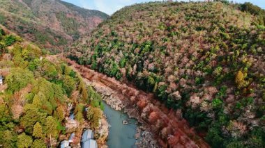 Dar nehrin üzerinde uçuyor, kayaların arasında kıvranıyor. Japonya, Kyoto 'daki resim dağları. Hava görünümü.