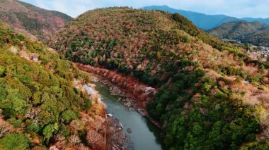 Ormanlarla kaplı güzel dağların büyüleyici manzarası ve ayağından akan dar nehir. Kyoto, Japonya 'nın güzel doğası. Hava görünümü.