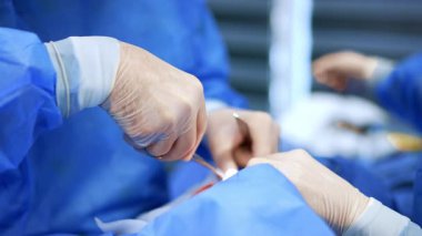 Beyaz lateks eldivenli cerrah ve hemşire elleri. Doktor plastik cerrahide metal aletler kullanıyor. Kapat..