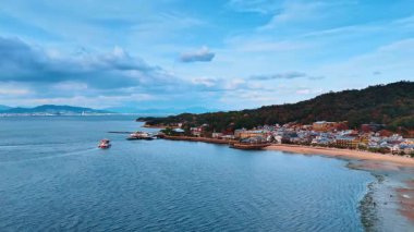 Seto İç Denizi kıyılarına güzel evler ve güzel doğa ile yaklaşıyoruz. Dağlara ve kayaların üstündeki bulutlara hava perspektifi. Japonya 'yı gezmek.