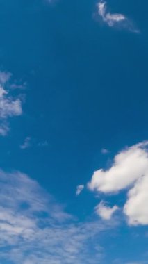 Yumuşak bulutlu, masmavi bir gökyüzü. Düşük açılı bir bakış açısıyla yaz günü ufku. Zaman ayarlı. Dikey video