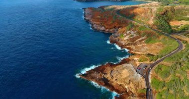 Hawaii, ABD 'deki Oahu Adası' nın kayalık kıyı şeridinin üzerindeki uçuş. Arabalar ikonik kıyı boyunca seyahat ederler. Hava perspektifi.