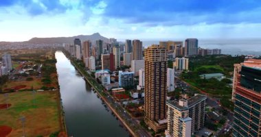 İnsansız hava aracı Honolulu 'daki Ala Wai Kanalı üzerinde uçuyor. Arkaplanda gri bulutların altında Pasifik Okyanusu manzarası gözler önüne seriliyor.