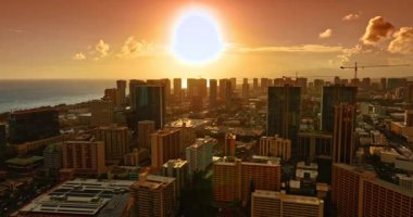 Muhteşem yumuşak altın ışık Honolulu, Hawaii 'nin yerleşim bölgesini kaplıyor. Günbatımında çarpıcı modern şehir manzarasının üzerinde insansız hava aracı görüntüleri.