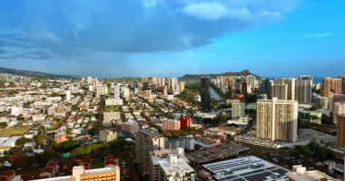 Şehir merkezinde yağmur bulutları toplanıyor. İnsansız hava aracı, Honolulu, Hawaii 'nin manzarasına yükseliyor. Arkaplanda Diamond Head Krateri.