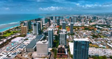 Pasifik Okyanusu kıyısındaki yüksek binaların üzerinde uçuş. Honolulu, Hawaii, ABD üzerinde güzel bulutlar var..