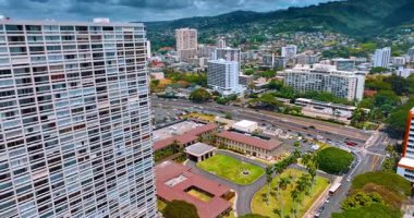 Gündüz vakti Honolulu yollarında hareketli bir trafik var. İnsansız hava aracı şehir panoramasının üzerinde yükseliyor ve dağların manzarasını gözler önüne seriyor.