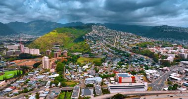 Honolulu, Oahu, ABD 'nin alçak katlı yerleşim bölgesi. Şehrin ve dağların üzerinde dramatik bulutlar toplanıyor. Hava perspektifi.