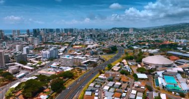 Arabalar modern Honolulu, Hawaii, ABD 'nin arazisinden hızla geçiyor. Güneşli ama bulutlu bir günde güzel şehre hava perspektifi.