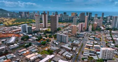 Pasifik Okyanusu kıyısındaki çok katlı binalara yaklaşıyoruz. Güneşli bir günde Honolulu, Hawaii, ABD 'nin hava manzarası.