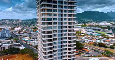 Honolulu, Oahu, ABD 'deki çok katlı bir yerleşim yerinden uzakta. Şehrin üzerinde dramatik bulutlar altında İHA görüntüleri.