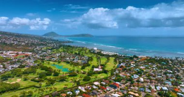 Honolulu, Hawaii kıyısındaki alçak katlı şehir manzarası. Pasifik Okyanusu 'nun masmavi su manzarası ve arka planda beyaz bulutlarla şehrin inanılmaz manzarası..