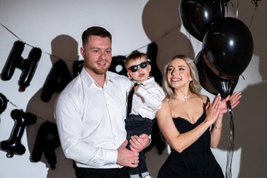 Aile doğum günü partisi eğlencesi! Mutlu bir aile, doğum gününü kutlamak için resmi giysiler içinde toplanır..