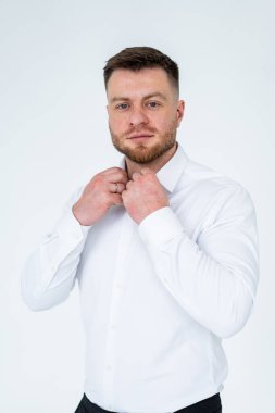 Resmi düzende tasma takan bir adam. İyi hazırlanmış bir adam, resmi bir olaya ya da minimalist bir ortamda fotoğraf çekimine hazırlanırken yakasını düzeltir..