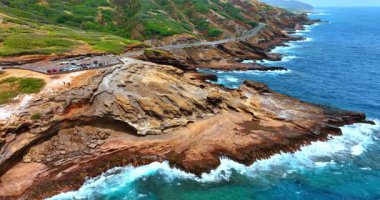 Gözlem güvertesi ve otoparkı olan muhteşem kayalık bir sahil. Güçlü dalgalar Hawaii, ABD sahillerindeki kayalara çarptı. İnsansız hava aracı görüntüleri.
