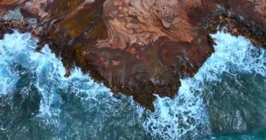 Pasifik Okyanusu Hawaii 'nin kayalık sahillerinde coşuyor. Köpüklü beyaz dalgalar kayalara çarpıyor. Üst görünüm.