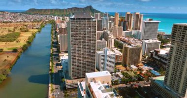 Ala Wai Kanalı 'nın kıyısındaki çok katlı yüksek binaya yaklaşıyoruz. Havadan bakıldığında Honolulu, Hawaii, ABD manzarası. Koko Kafa Krateri arkaplanda.