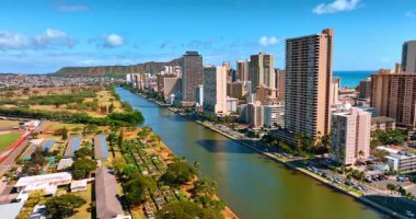 Waikiki boyunca Ala Wai Kanalı üzerinde uçuyor. Honolulu 'nun güneşli manzarası, Hawaii, ABD Koko Kafa Krateri ile arka planda.
