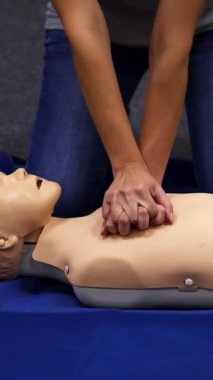 Bebek suni teneffüs sahte ilk yardım eğitimi. Paramedikler göğüs sıkışması olan mankene kardiyopulmoner resüsitasyon uyguluyorlar. Dikey video