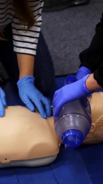 İçeride ilk yardım eğitimi. Bebek eğitmenle boğulduğunda insanlar hayat kurtarmayı öğreniyor. Dikey video