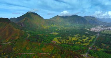 Hawaii 'nin parlak doğası. Vadinin yukarısında uçuşlar güzel dağlarla çevrilidir. Bulutlar kayaların tepesinde. Arkaplanda ikamet alanı.