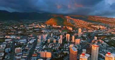 Gün batımında ABD 'nin Honolulu kentinin üzerindeki görüntüler. Arkaplanda dağların üzerindeki dramatik kara bulutlar kapladı..