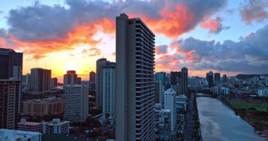 Honolulu, Hawaii, ABD 'deki Ala Wai Kanalı' nın üzerindeki yüksek bina boyunca yükseliyor. Arka planda gökyüzünde inanılmaz renkli bulutlar. Kentsel şehrin günbatımı görünümü.